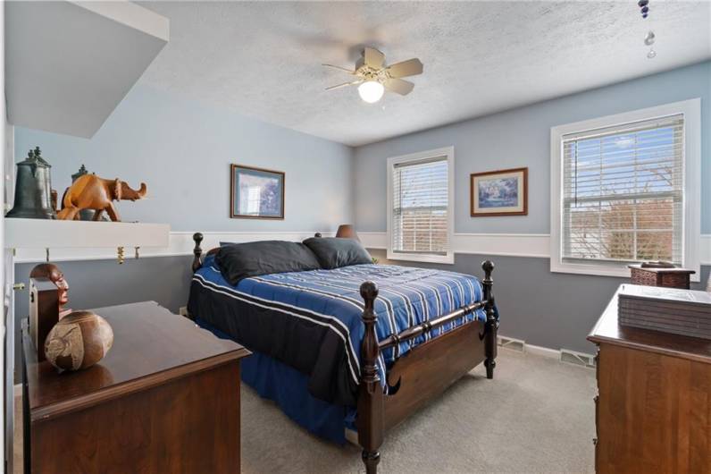 This generous sized bedroom offers plush neutral carpet, fresh paint, lighted ceiling fan, and a spacious walk-in closet.