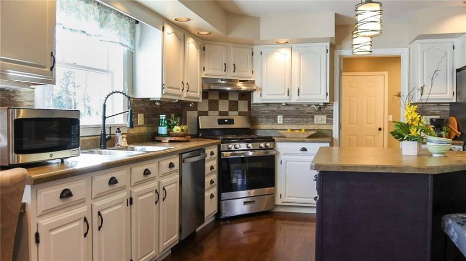 Hardwood floors in the kitchen with new stainless appliances in 2023