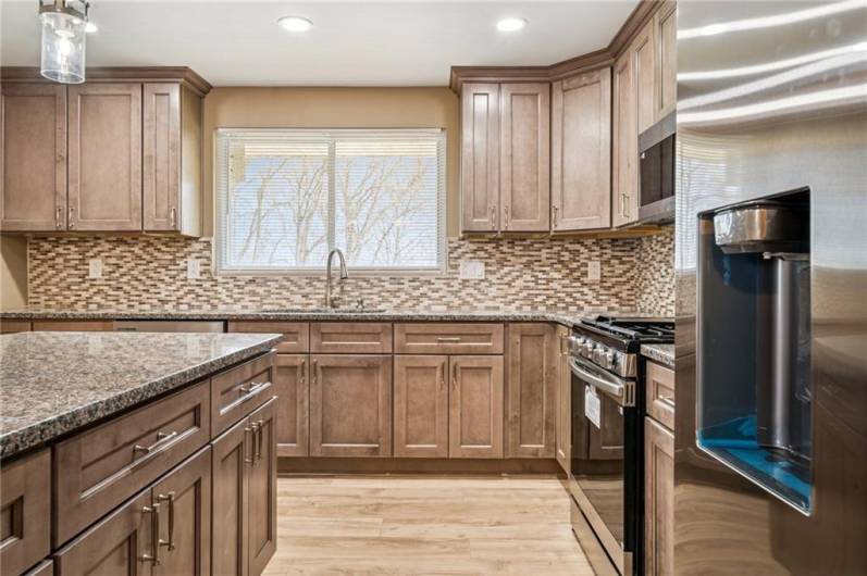 STUNNING KITCHEN WITH CORRESPONDING BACKSPLASH, NEW CABINETS, FIXTURES, ETC.