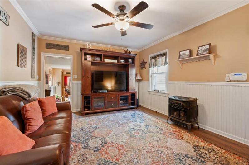 The other entry into this turnkey home, as you enter into the den area with crown molding, hardwood flooring and beadboard molding.