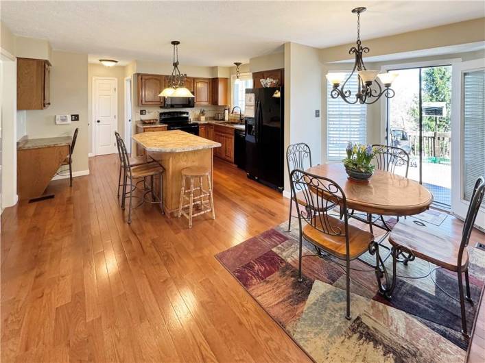 Large kitchen with center island, planning desk and hardwood floors.