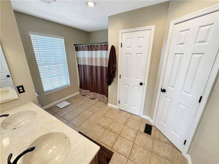 The master bath has a dual bowl vanity sink, linen closet, and a walk-in closet.