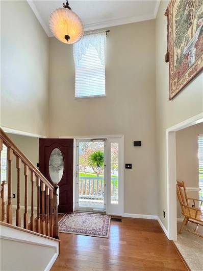 Dramatic two-story entry with hardwood flooring.
