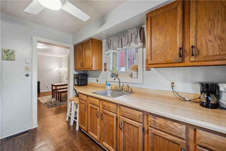 Updated kitchen with an abundance oak cabinetry, ceiling fan, & amble counterspace.