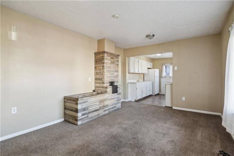 Spacious formal dining room with decorative stone fireplace.