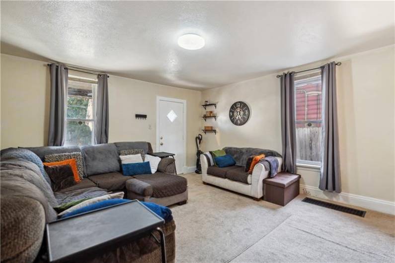Spacious living room with updated carpet and neutral color scheme.