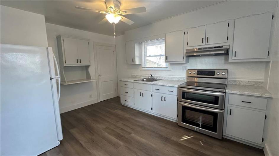 Freshly painted walls, cabinets.  New counter top, hooded fan and fixtures.  Newer double oven and refrigerator,  New floor. Door is to basement.