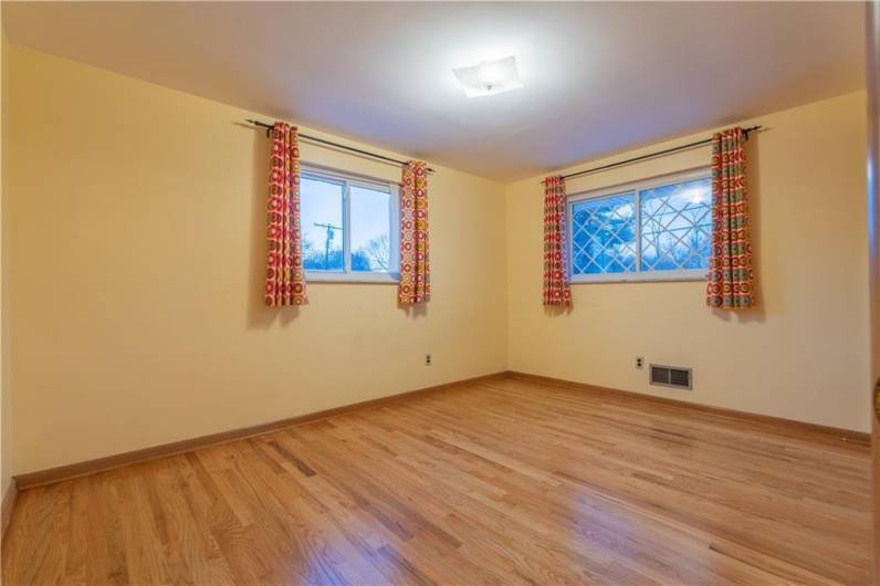 The second bedroom is located at the front of the house and has windows on two sides.
