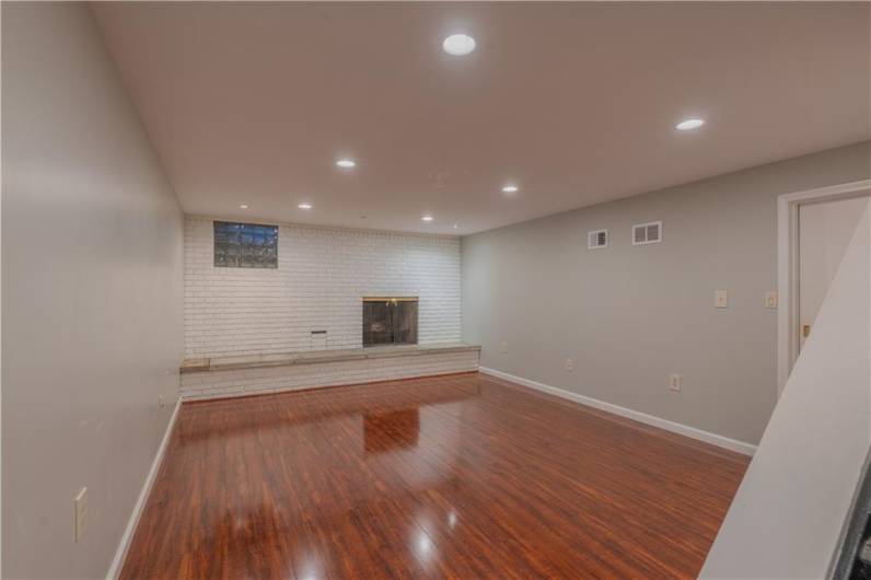 The lower level family room has newer vinyl floors ad a second wood burning fireplace.