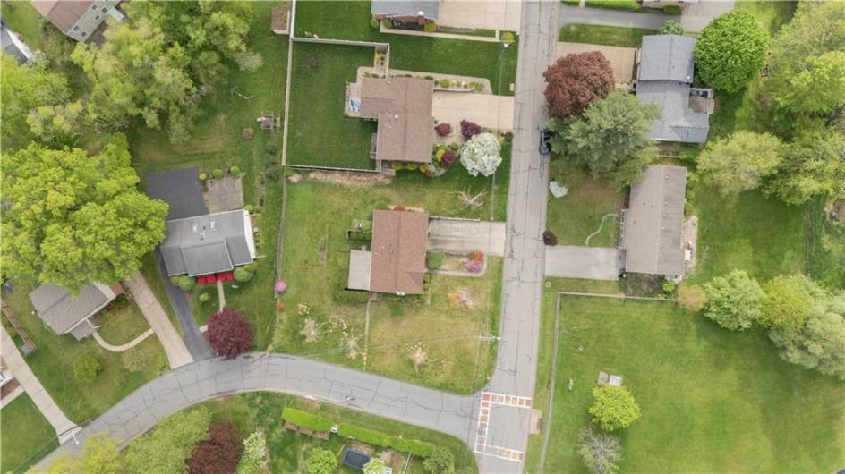 Aerial view of the large corner lot. The crosswalk shows the close proximity of the bus stop.