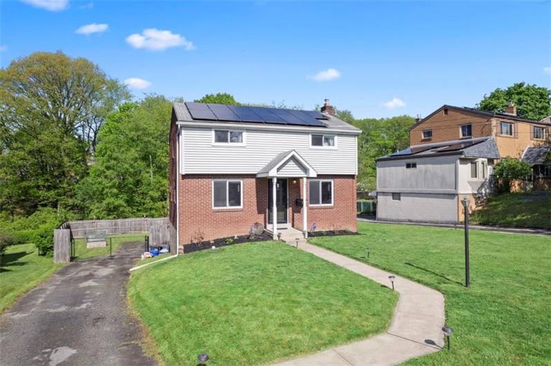 A long driveway for ample parking along side beautiful front yard.