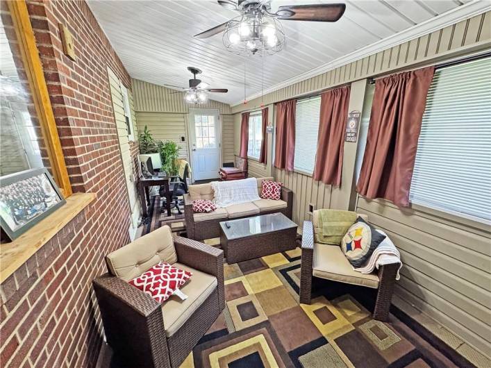 Enclosed porch with two ceilings fans.
