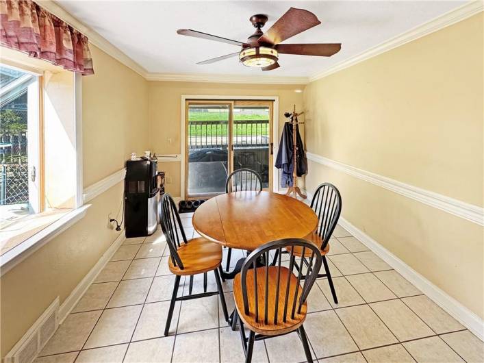 Large dining room has newer greenhouse window and sliding glass door.