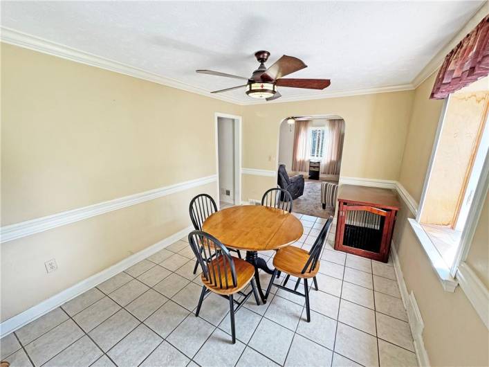 The dining room has crown and chair rail moldings and a ceramic tile floor.