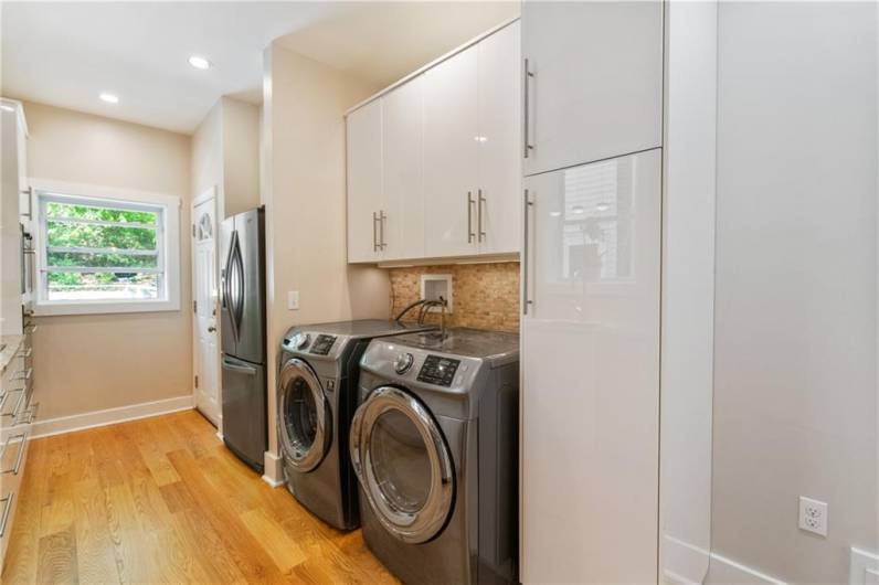 Laundry equipment is conveniently located in the kitchen (there is also a second set of laundry hookups in the basement). The door at the end of the kitchen leads to the back yard deck