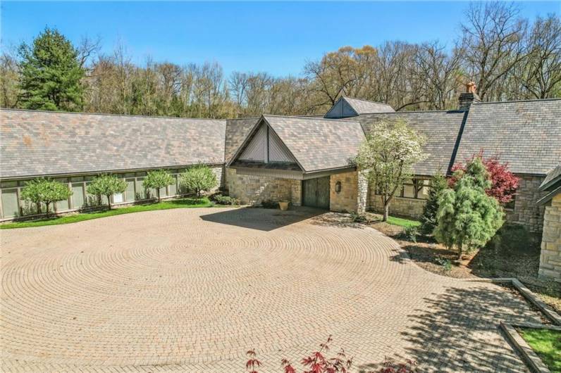 Meticulously bricked courtyard, offering seamless access to the main residence, a substantial five-car garage, and two private one-bedroom apartments.