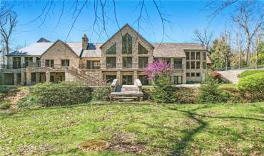 Commanding attention with its impressive facade and harmonious integration with the lush, private landscape, winding staircase, stone bridge & extensive balconies we present 1700 Forker.
