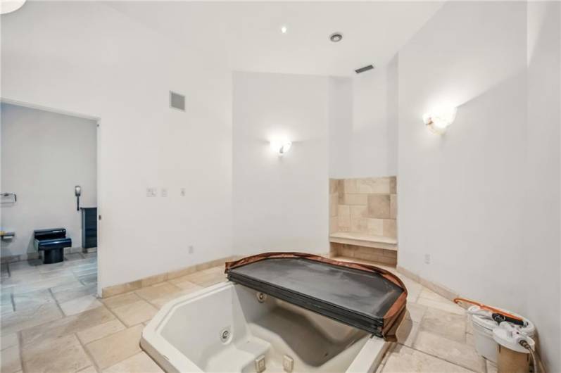 Hot tub anchors the 2 primary bathroom & dressing room suites.