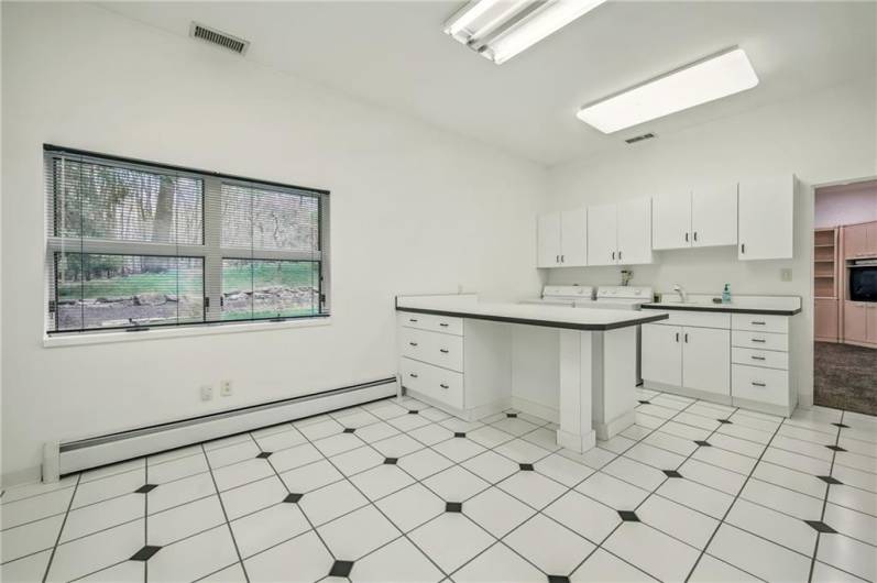 Expansive 1st floor laundry with ample storage & folding counters