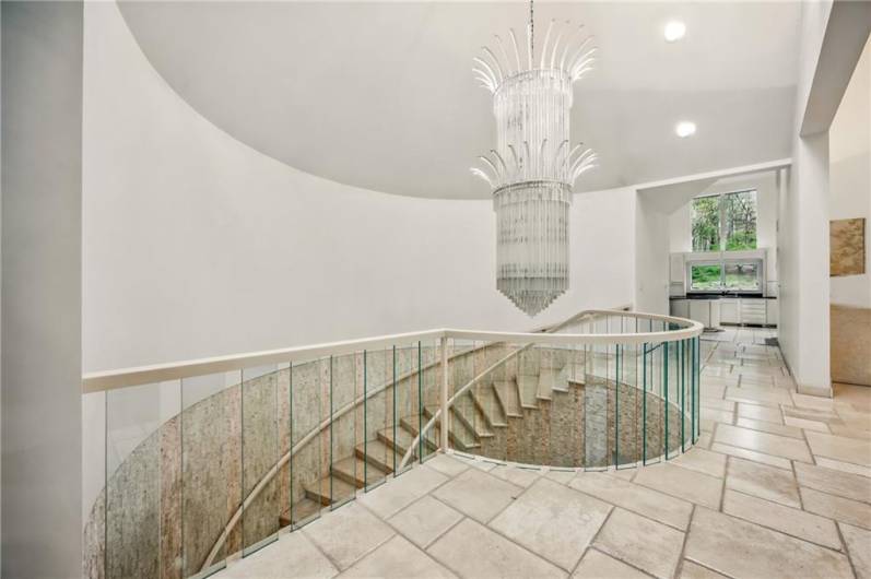 A symphony of design: this residence boasts a breathtaking spiraling staircase, crowned by a magnificent chandelier and surrounded by impressive architecture.