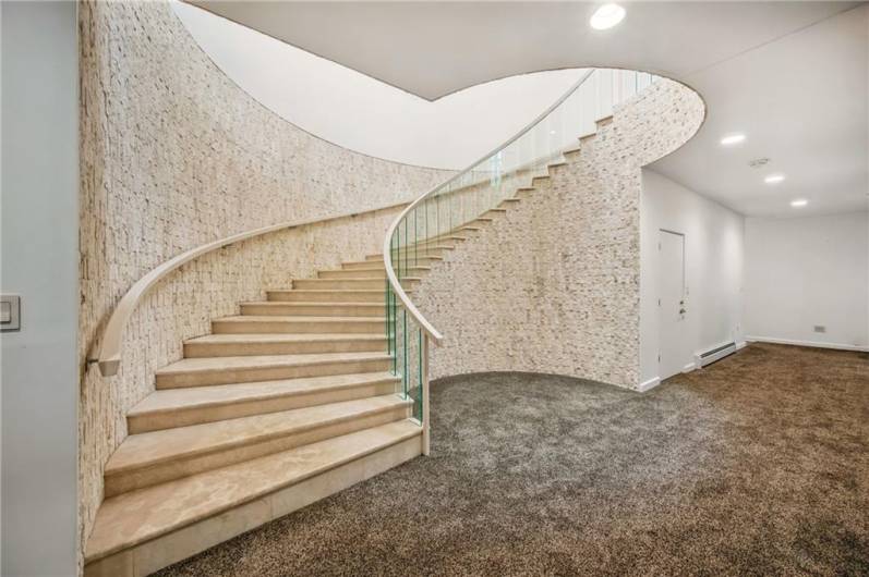 The heart of the home is defined by this stunning curved staircase, a testament to thoughtful design and exquisite materials.