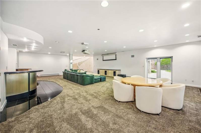 Generously sized lower level family room offers the ultimate in relaxation and entertainment. Enjoy seamless transitions from casual lounging to sophisticated cocktails at the wet bar, or transform the space into a private home theater with the integrated projector