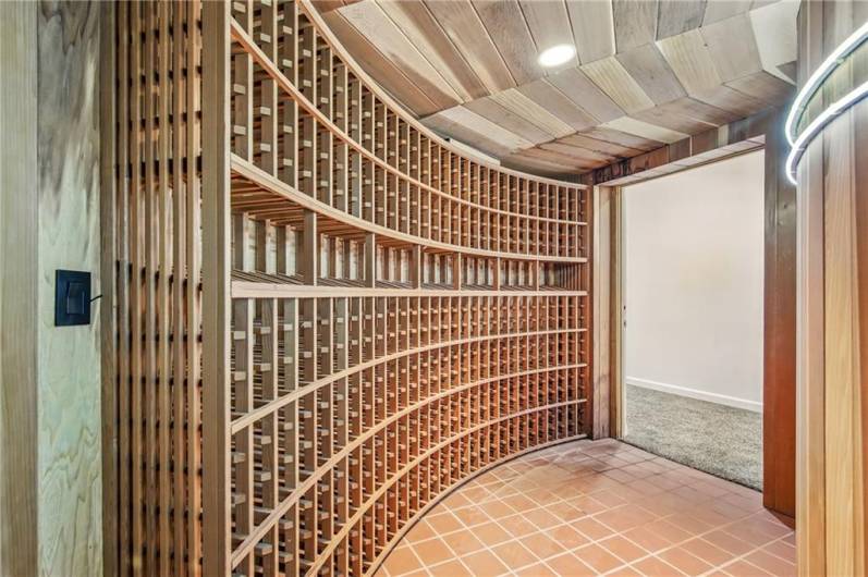 A distinguished wood wine room awaits the discerning collector. Capable of housing just under 600 bottles, this beautifully appointed space offers the ideal climate and elegant racking to preserve and showcase your exceptional vintages within this remarkable estate.