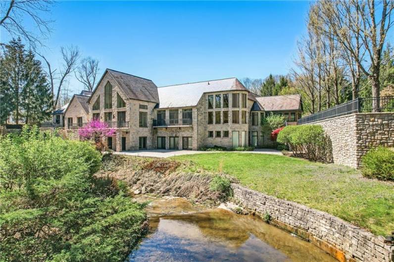 Discover a harmonious blend of architectural grandeur and natural beauty. This exceptional estate gracefully overlooks a tranquil stream, offering a picturesque setting and the soothing sounds of nature as a backdrop to luxurious living.