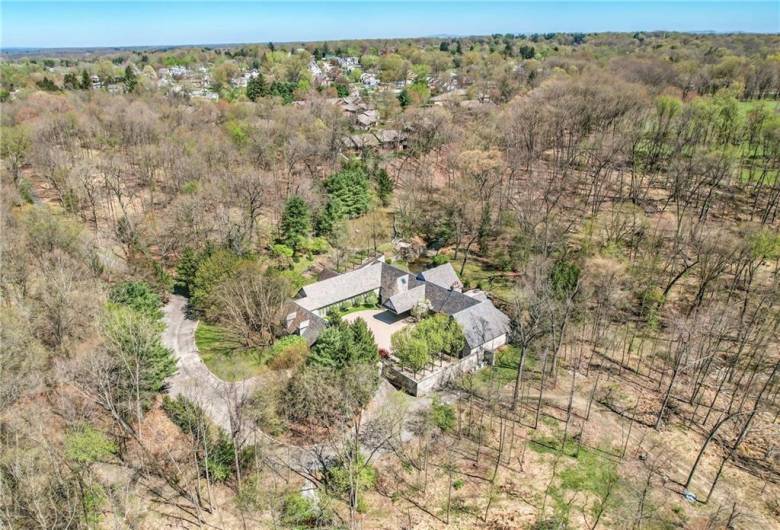 The long, winding driveway hints at the secluded elegance that awaits within this unparalleled estate