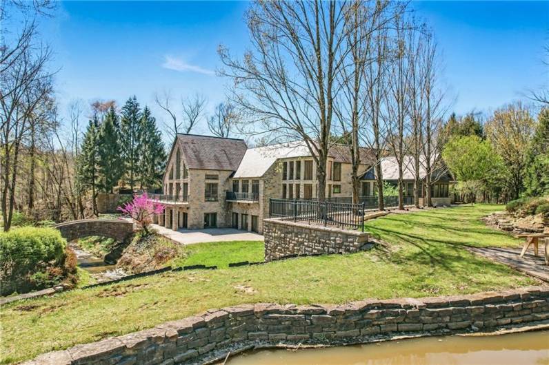 Private sanctuary where architectural grandeur meets the tranquility of nature, complete with its own stone bridge and picturesque stream & private lake.