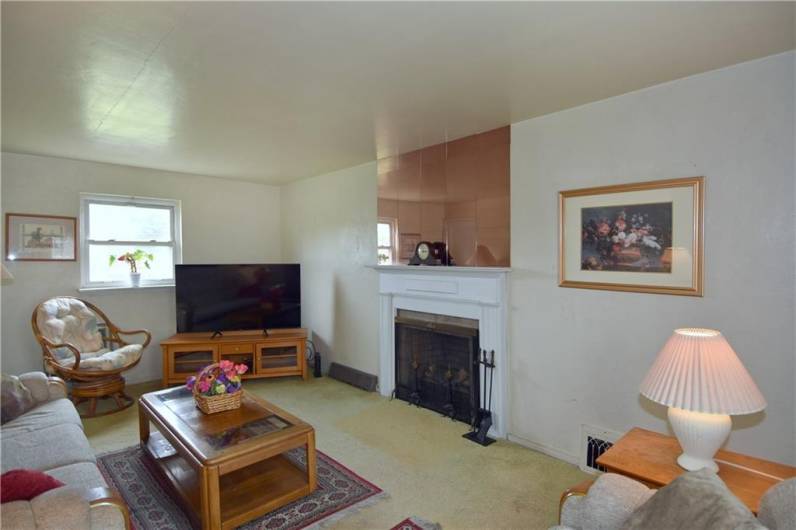 18 x 11  Neutral walls, mirrors above fireplace, appears to be electric logs, but unsure, hardwood under carpeting