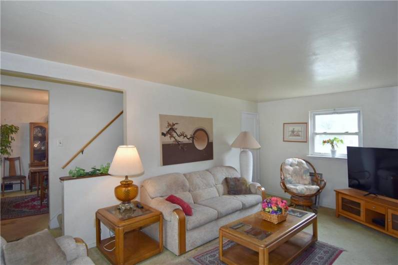 View to dining room and stairway. Coat closet in corner near window