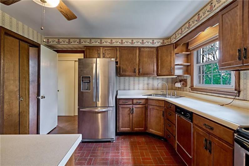 Kitchen has newer stainless steel refrigerator, electric stove, and built in microwave. To the left side are 2 generously sized pantries. In the background is another large closet and to the right is the main floor full bath.