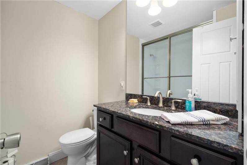 Hall Bath with a Granite Topped Vanity, Neutral Tile Flooring and a Tub/Shower Combo