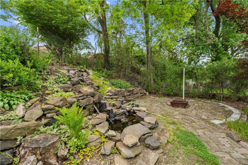 Patio next to pond and fire pit