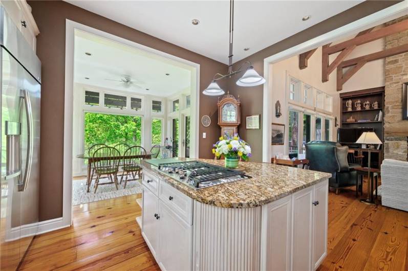 Kitchen flows into breakfast area with lush garden views.