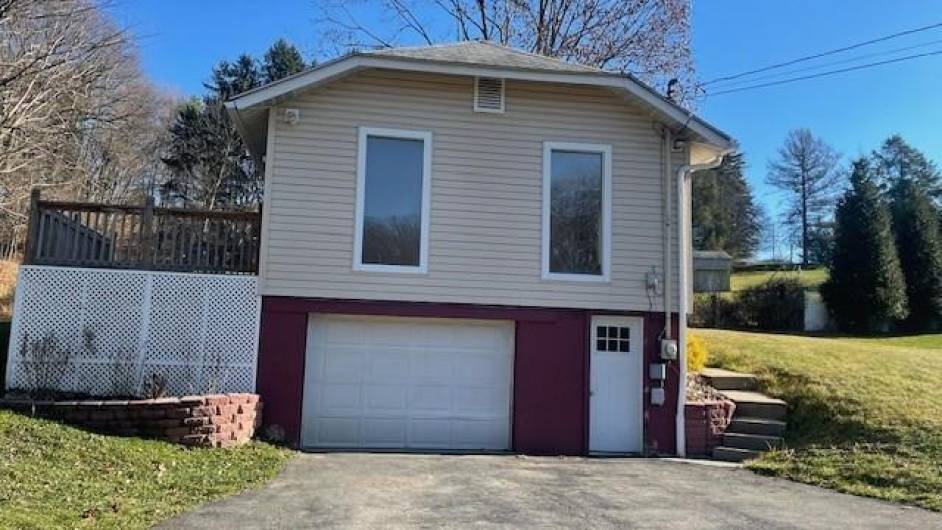 Charming two-story home with spacious garage, expansive deck, and serene wooded surroundings—perfect for relaxing or entertaining