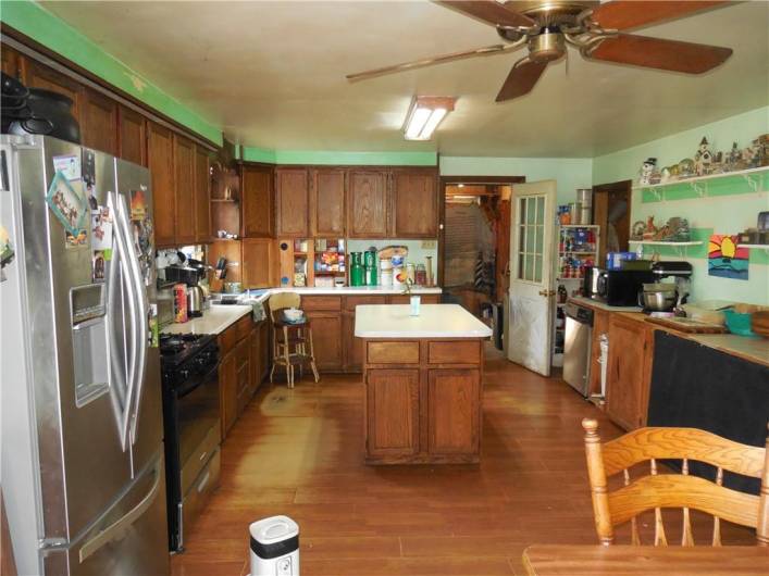 Large open kitchen leads to back storage room.
