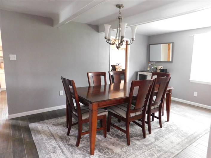 Dining Room with ceiling beams and nice hanging chandelier. Nice natural lighting from the window.