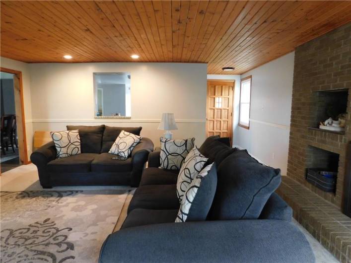 Nice Family Room with wood ceiling, chair rail, and woodburning fireplace with a gas starter.