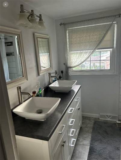 updated Primary Bathroom with double bowl sinks, vanity with drawers and closets. Very nicely done.