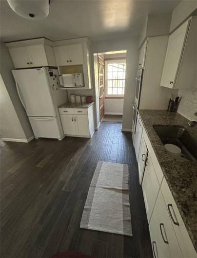 Updated Kitchen with granite countertops, double ovens, gas stove top, dishwasher, and disposal.
