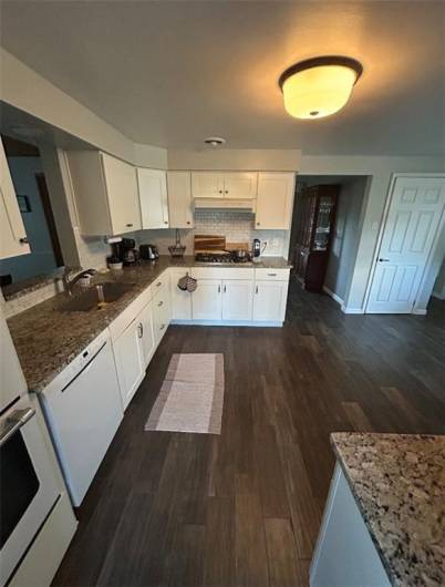 Kitchen with double ovens, recessed light, and pantry.