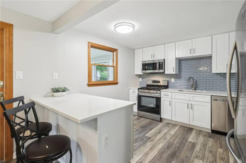 UPDATED! Stainless steel appliances, backsplash, cabinets, garbage disposal and penninsula for extra seating