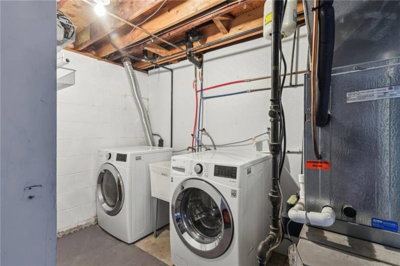 Clean laundrey room with quality front loader washer & dryer and updated plumbing lines