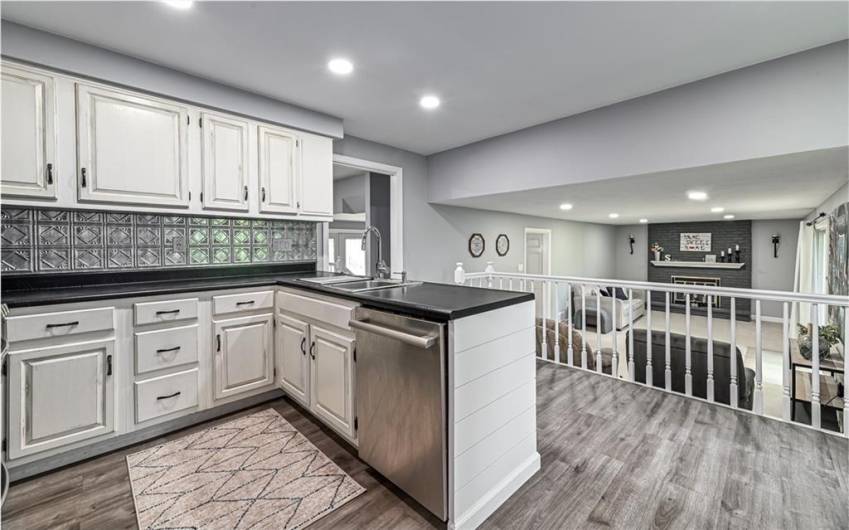Kitchen features wood look easy to maintain luxury vinyl flooring.