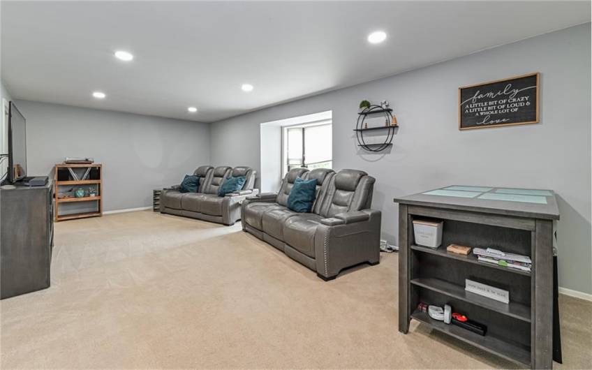 Sun drenched spacious living room with recessed lighting.