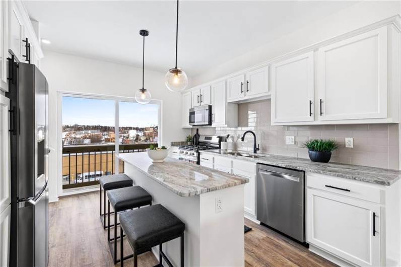 Stunning custom kitchen with stone counters, bright cabinetry, and stainless steel appliances *Photo of model home at 21 Rose