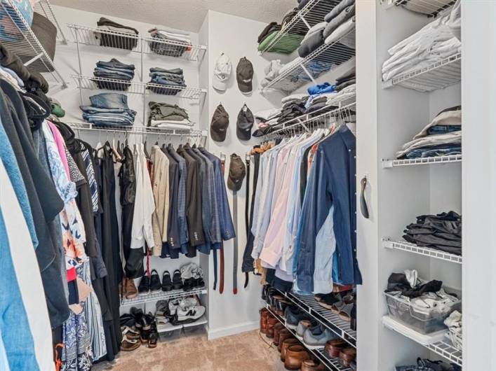 This impressive primary walk-in closet offers exceptional organization and storage space with built-in shelving, hanging racks, and dedicated compartments for shoes and accessories.