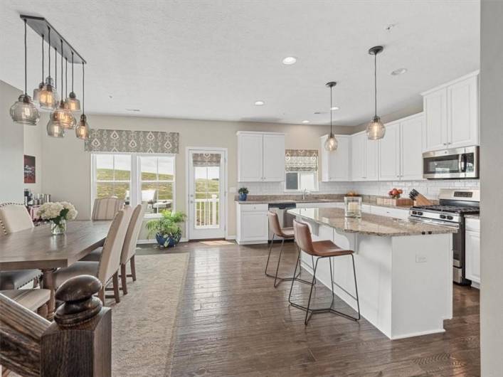 This stunning kitchen is the heart of the home, featuring crisp white cabinetry, granite countertops, and stainless steel appliances for a sleek, modern look.